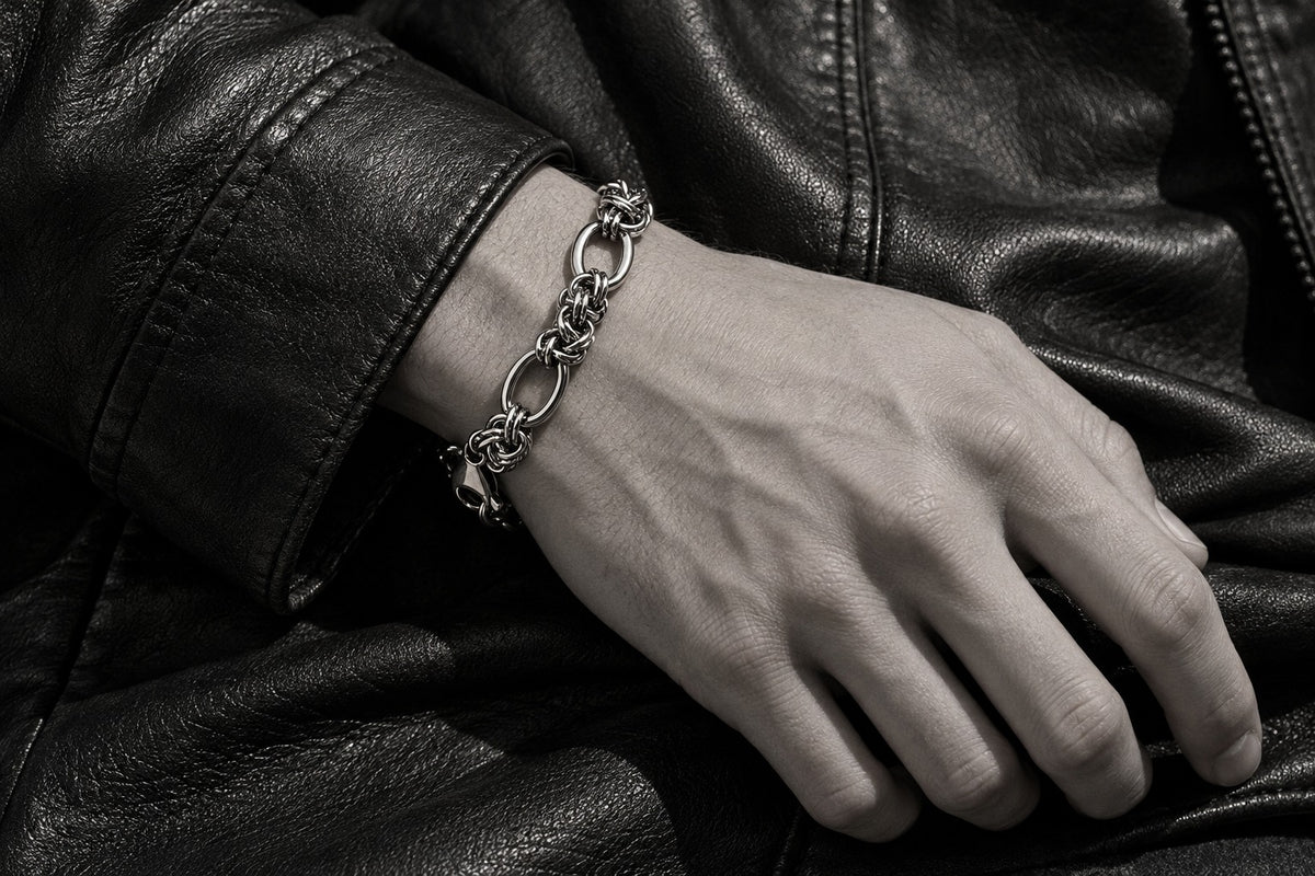 Eine Hand mit silbernem Armband auf schwarzem Leder